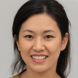 Joyful asian young-adult female with medium  brown hair and brown eyes