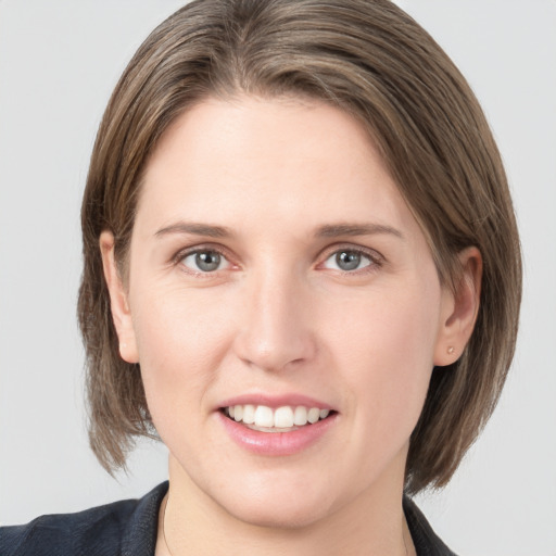 Joyful white young-adult female with medium  brown hair and grey eyes