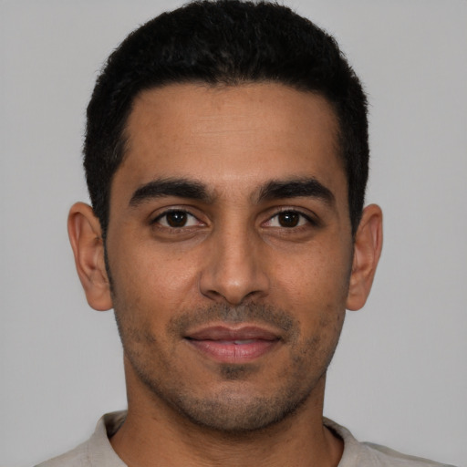 Joyful latino young-adult male with short  black hair and brown eyes