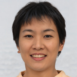 Joyful asian young-adult female with short  brown hair and brown eyes