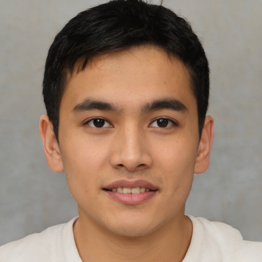 Joyful asian young-adult male with short  black hair and brown eyes