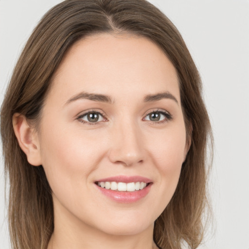 Joyful white young-adult female with long  brown hair and grey eyes