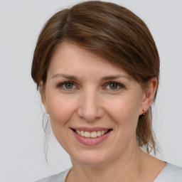 Joyful white young-adult female with medium  brown hair and grey eyes