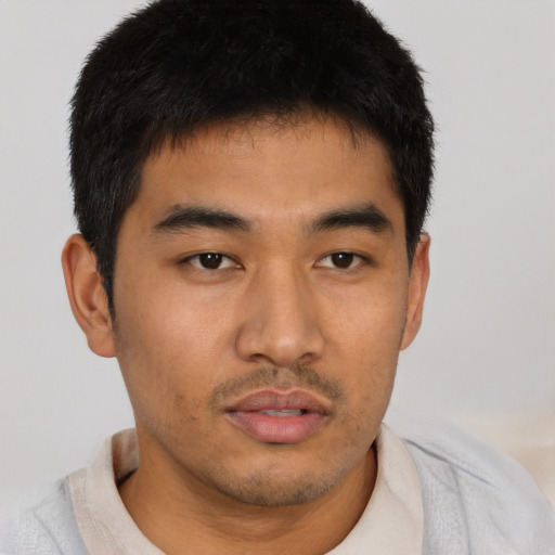 Joyful asian young-adult male with short  black hair and brown eyes