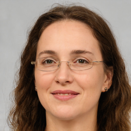 Joyful white adult female with long  brown hair and green eyes