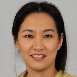 Joyful asian young-adult female with medium  brown hair and brown eyes