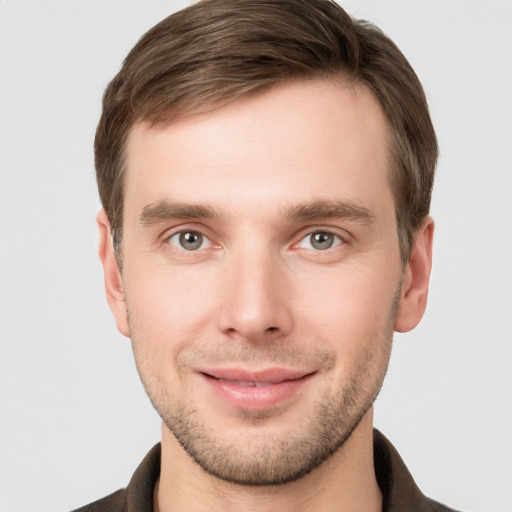 Joyful white young-adult male with short  brown hair and grey eyes