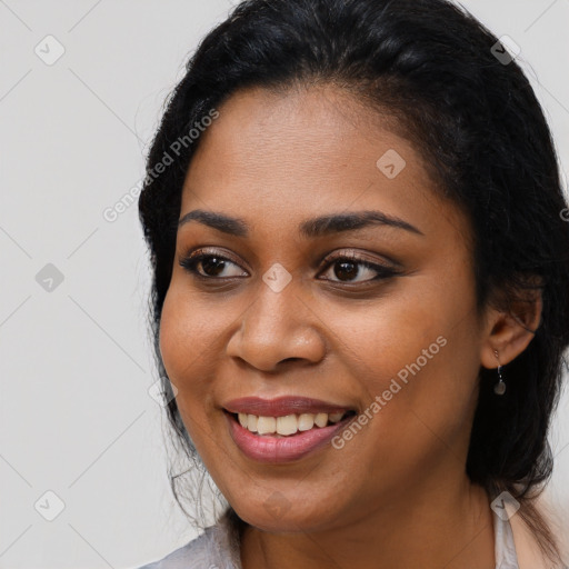 Joyful black young-adult female with long  black hair and brown eyes