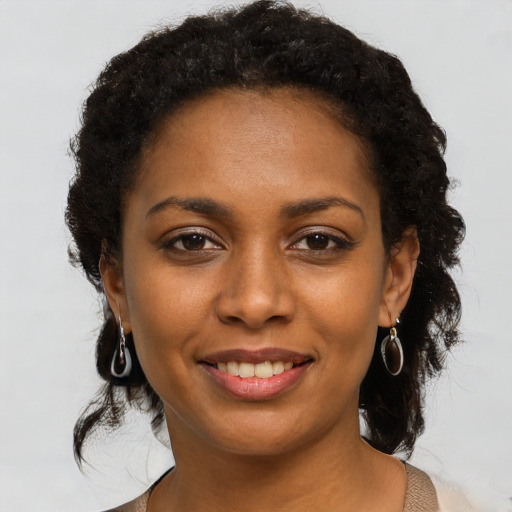 Joyful black young-adult female with long  brown hair and brown eyes
