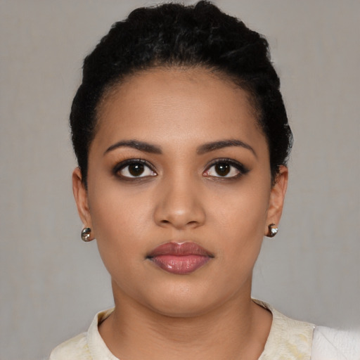 Joyful latino young-adult female with short  black hair and brown eyes