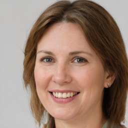 Joyful white adult female with medium  brown hair and grey eyes