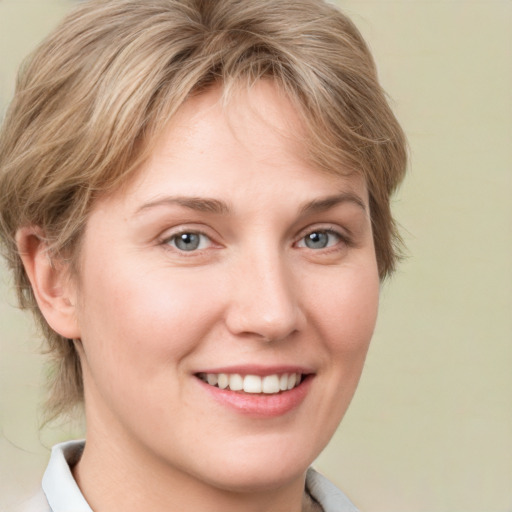 Joyful white young-adult female with short  brown hair and blue eyes