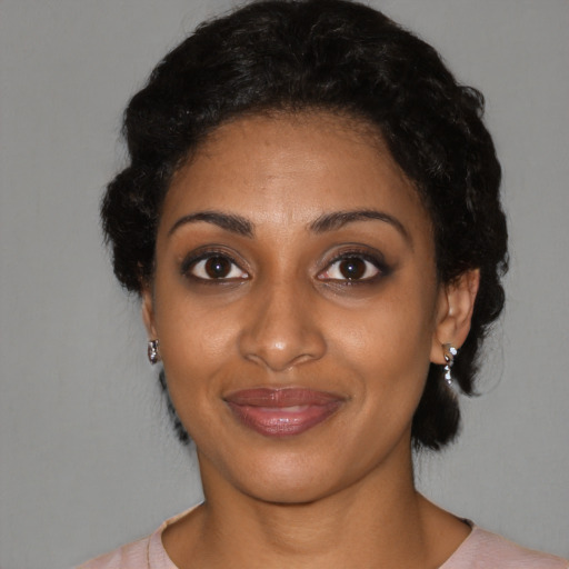 Joyful black young-adult female with short  black hair and brown eyes