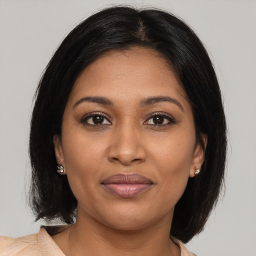 Joyful black young-adult female with medium  brown hair and brown eyes