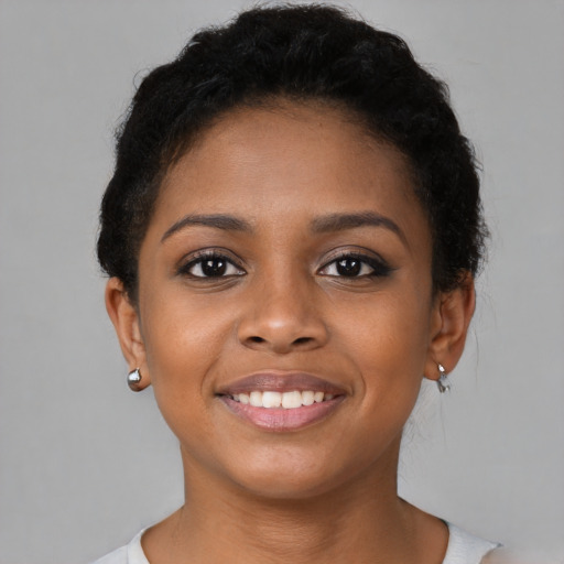 Joyful black young-adult female with short  black hair and brown eyes