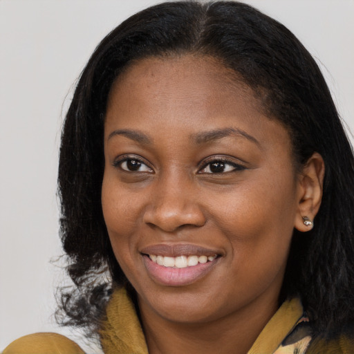 Joyful black young-adult female with long  brown hair and brown eyes