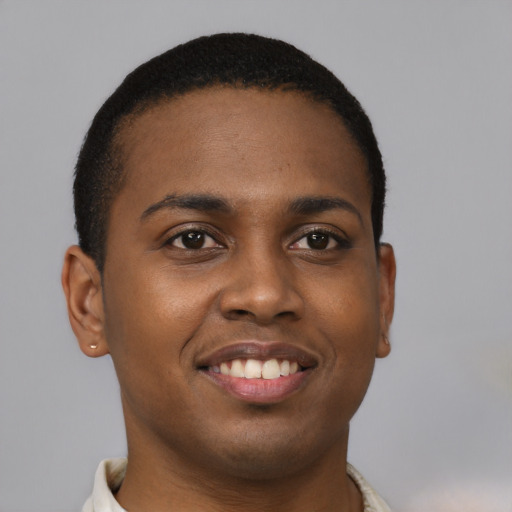 Joyful black young-adult male with short  brown hair and brown eyes