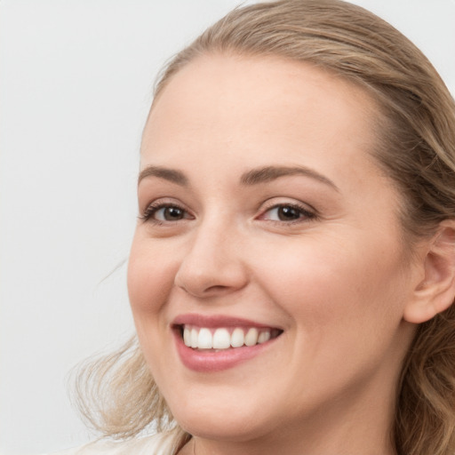 Joyful white young-adult female with long  brown hair and blue eyes