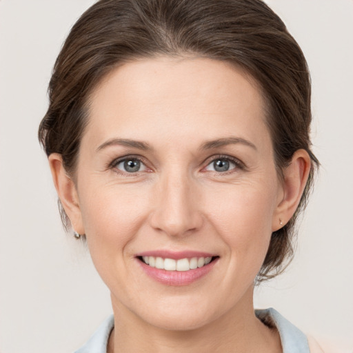 Joyful white young-adult female with medium  brown hair and grey eyes