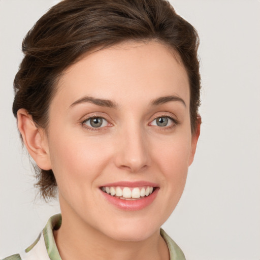 Joyful white young-adult female with medium  brown hair and green eyes