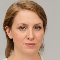 Joyful white young-adult female with medium  brown hair and green eyes