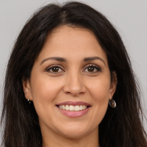 Joyful white adult female with long  brown hair and brown eyes