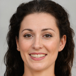 Joyful white adult female with long  brown hair and brown eyes