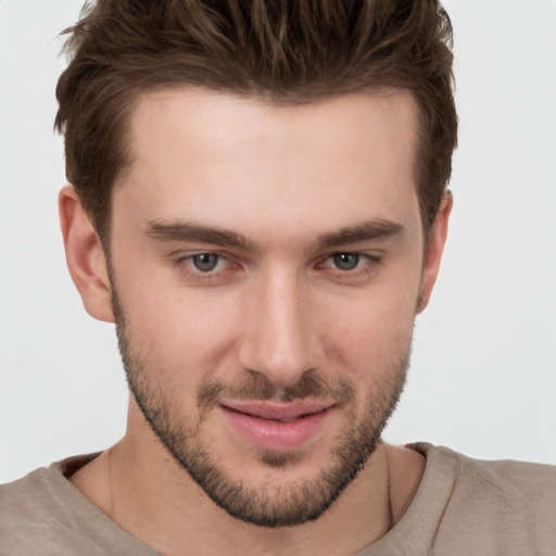 Joyful white young-adult male with short  brown hair and grey eyes