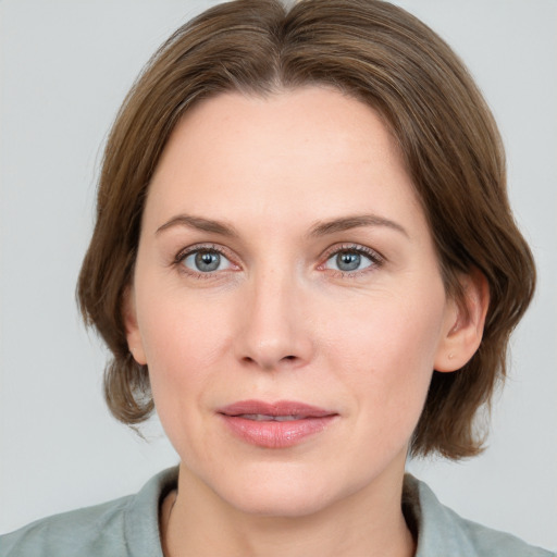 Joyful white young-adult female with medium  brown hair and blue eyes