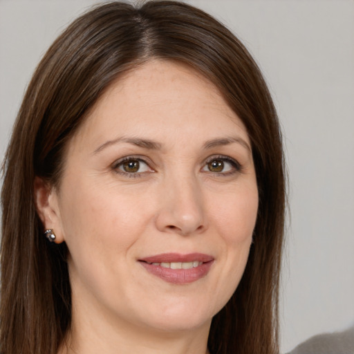 Joyful white adult female with long  brown hair and brown eyes