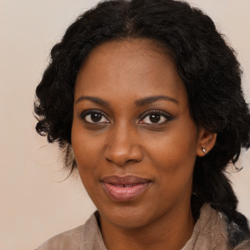 Joyful black adult female with long  black hair and brown eyes
