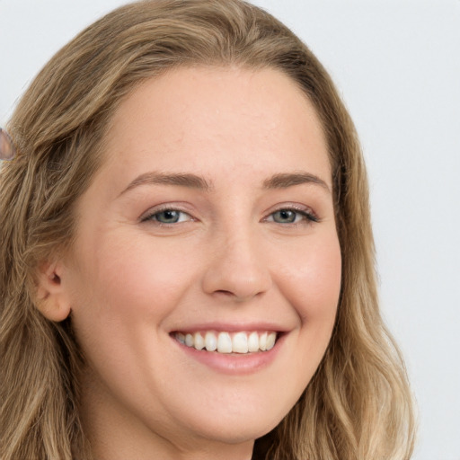 Joyful white young-adult female with long  brown hair and green eyes