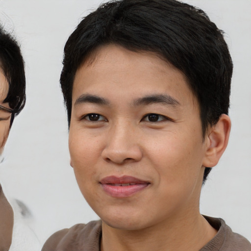 Joyful asian young-adult male with short  brown hair and brown eyes
