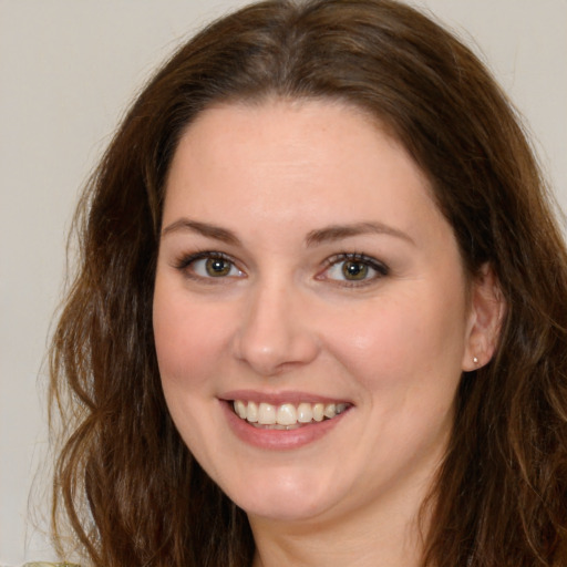 Joyful white young-adult female with long  brown hair and green eyes