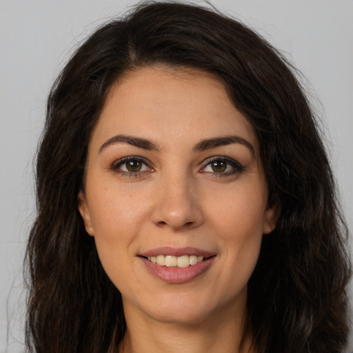 Joyful white young-adult female with long  brown hair and brown eyes