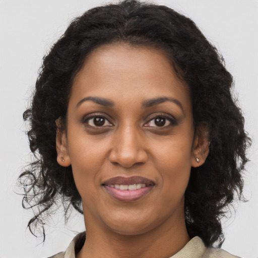 Joyful black young-adult female with long  brown hair and brown eyes