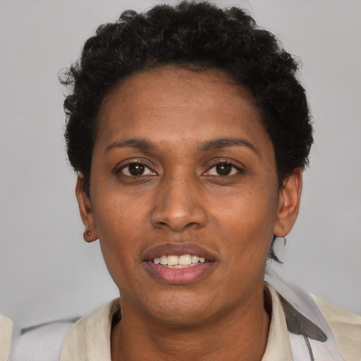 Joyful black young-adult female with short  black hair and brown eyes