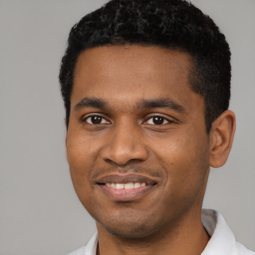 Joyful black young-adult male with short  black hair and brown eyes