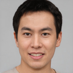 Joyful asian young-adult male with short  brown hair and brown eyes