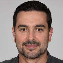 Joyful white young-adult male with short  black hair and brown eyes