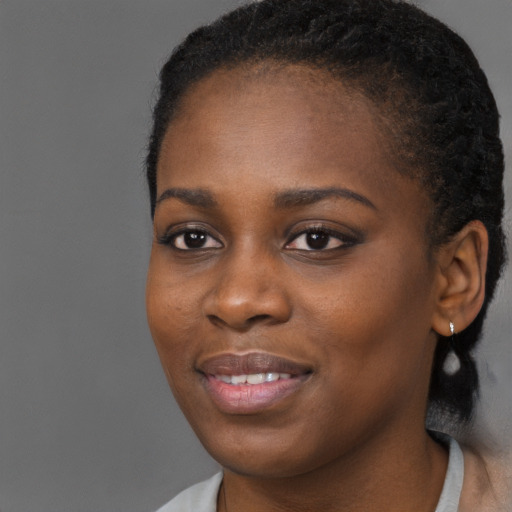 Joyful black young-adult female with short  brown hair and brown eyes