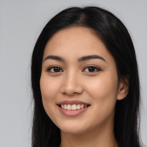 Joyful latino young-adult female with long  black hair and brown eyes