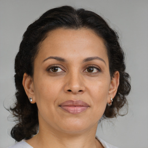 Joyful latino adult female with medium  brown hair and brown eyes