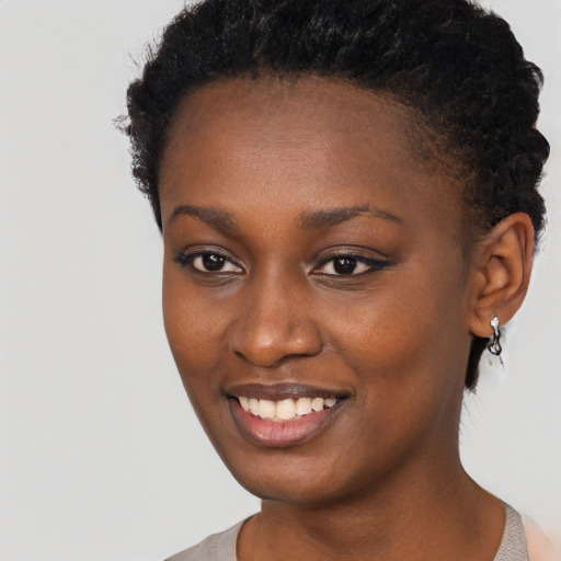 Joyful black young-adult female with short  brown hair and brown eyes