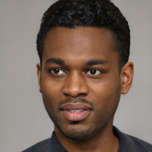 Joyful black young-adult male with short  black hair and brown eyes