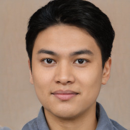 Joyful asian young-adult male with short  black hair and brown eyes