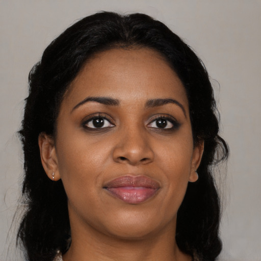 Joyful black young-adult female with long  black hair and brown eyes