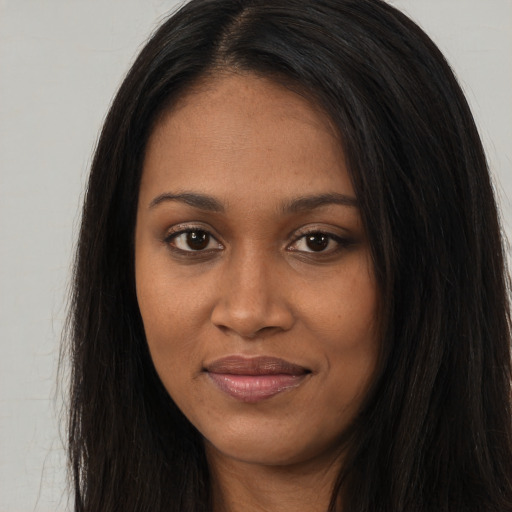 Joyful black young-adult female with long  brown hair and brown eyes