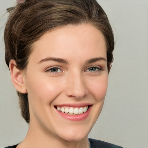 Joyful white young-adult female with medium  brown hair and grey eyes