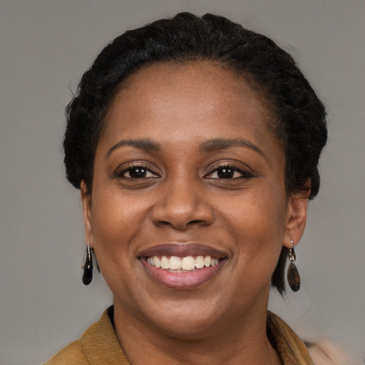 Joyful black adult female with short  brown hair and brown eyes